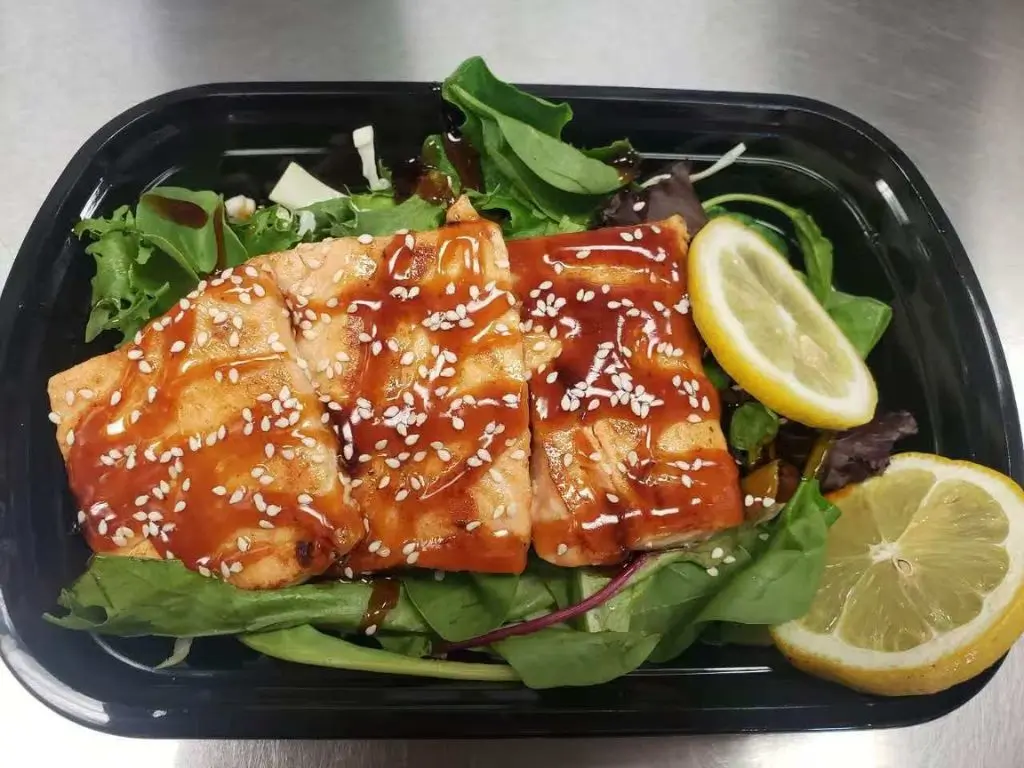 Luv-Ramen-&-BBQ-Japanese-restaurant-Salmon-Salad-Bowl-Hawthorne Salad bowl with grilled salmon topped with sesame seeds, mixed greens, and lemon slices at Luv Ramen & BBQ, a Japanese restaurant in Hawthorne