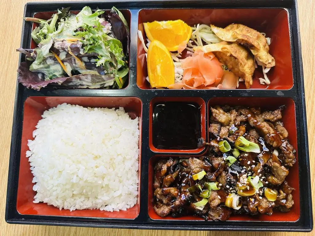 Luv-Ramen-&-BBQ-Japanese-restaurant-Teriyaki-Beef-Bento-Hawthorne Bento with teriyaki beef, white rice, mixed greens salad, orange slices, potstickers at Luv Ramen & BBQ, a Japanese restaurant in Hawthorne